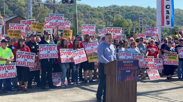 Dave McCormick speaks in front of a crowd of workers whose signs read "KEEP MAKING PYREX IN CHARLEROI" and "BOB STAYS, PA STAYS."